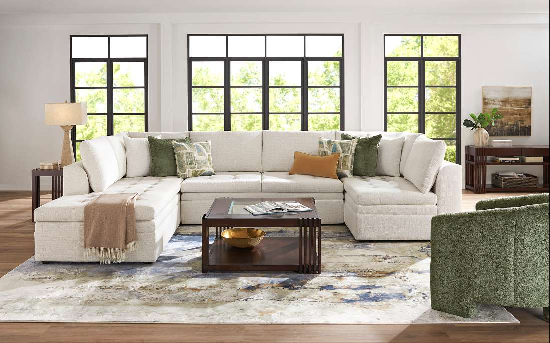 A sectional sofa with throw pillows, a coffee table, and a green armchair.
