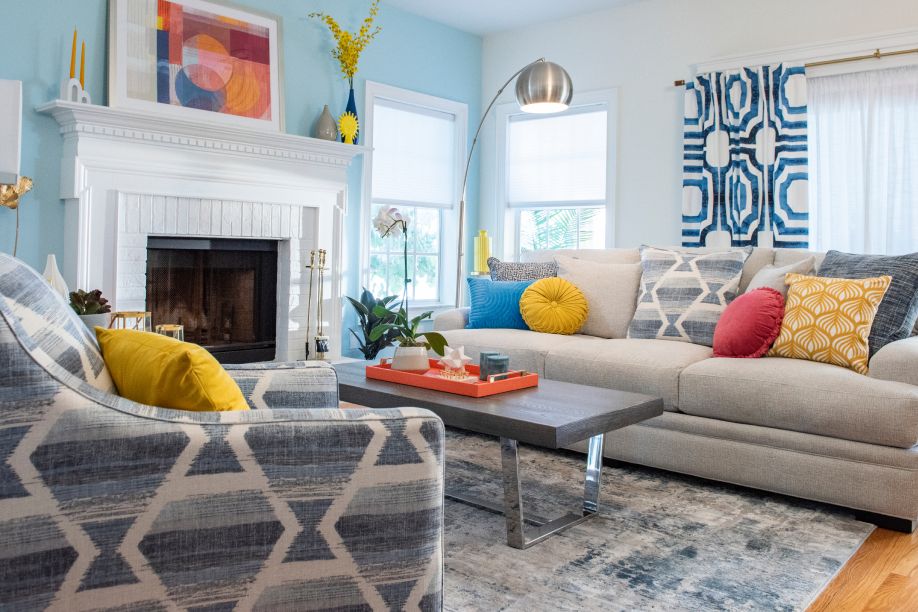 Living room with a gray sofa, patterned chair, and blue walls.
