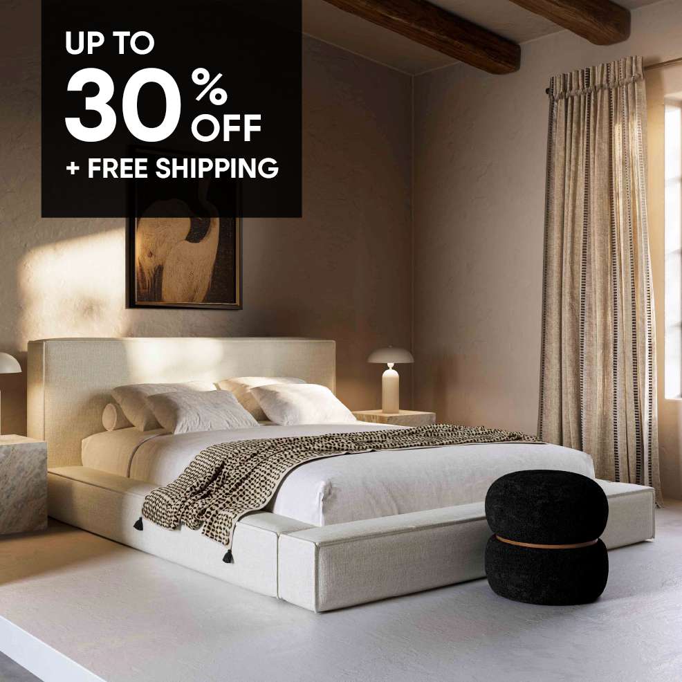 UP TO 30% OFF + FREE SHIPPING. A bedroom with a bed, lamps, and a black ottoman.
