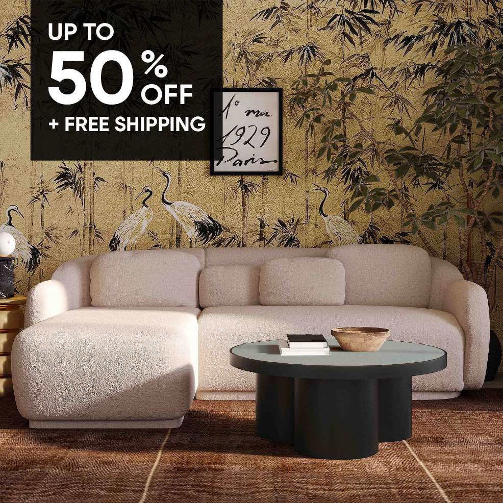 UP TO 50% OFF + FREE SHIPPING. A cream-colored sectional sofa with a round black coffee table.
