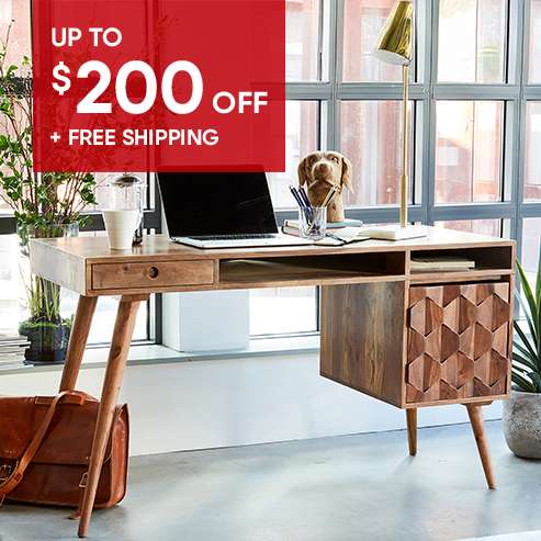 Up to $200 off + Free Shipping. Wooden desk with a laptop, lamp, and dog statue.
