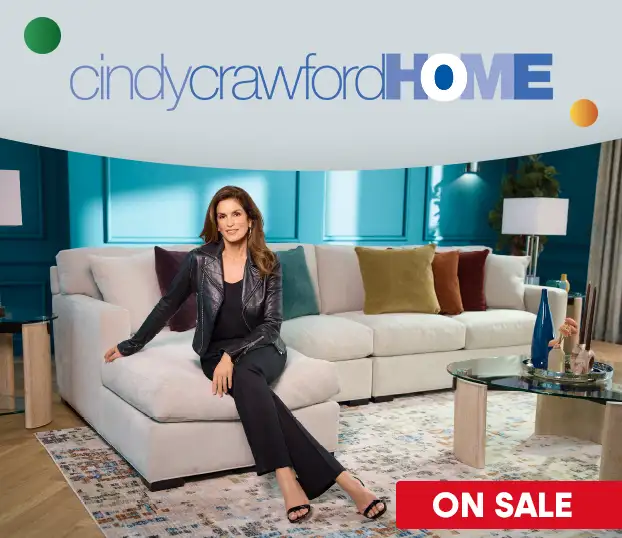cindy crawford HOME ON SALE. Cindy Crawford sitting on a white sectional sofa.