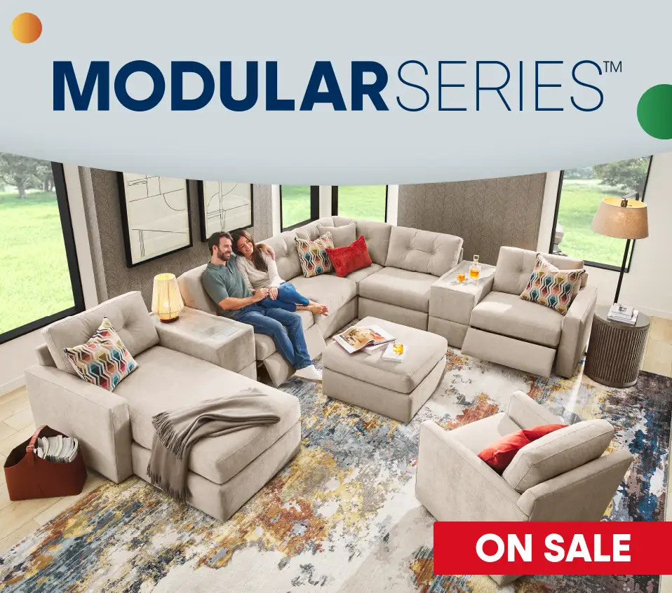 MODULAR SERIESâ„¢ ON SALE. A couple relaxes on a beige modular sofa in a living room.