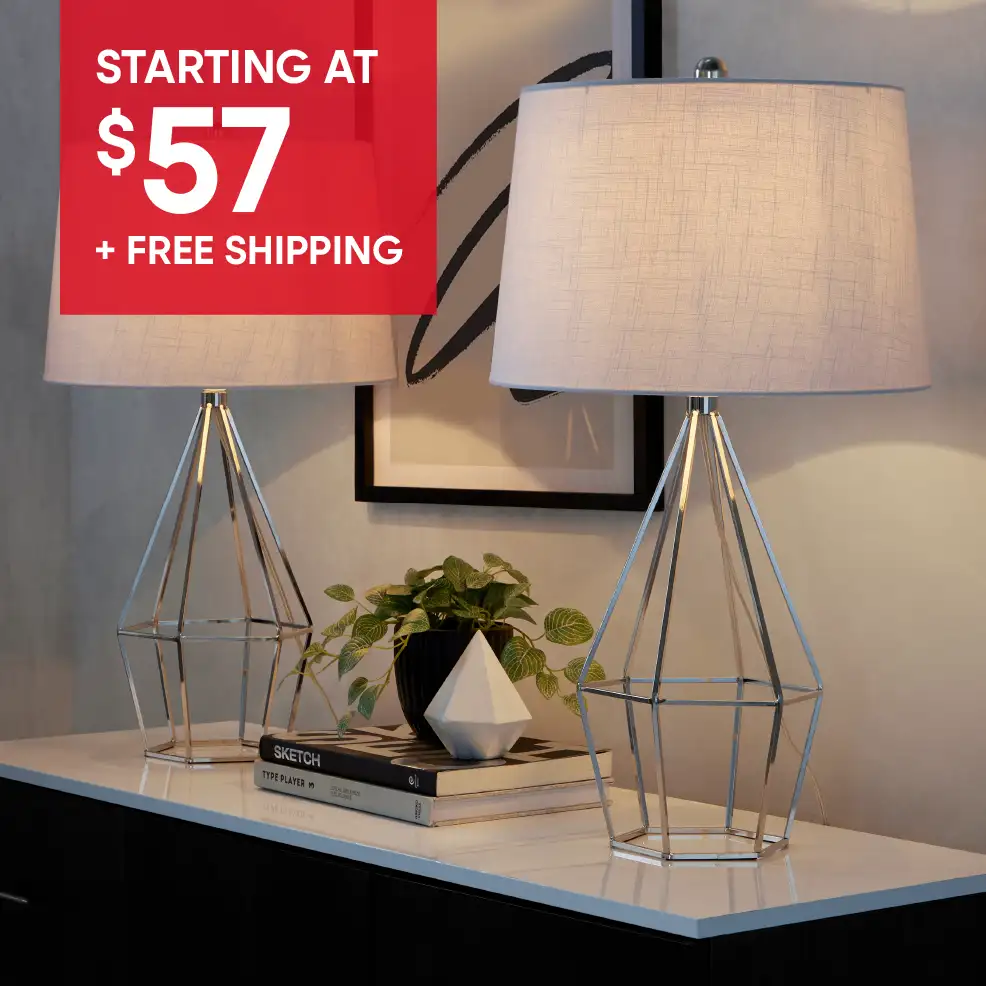 STARTING AT $57 + FREE SHIPPING. Two silver lamps with gray shades on a white surface.