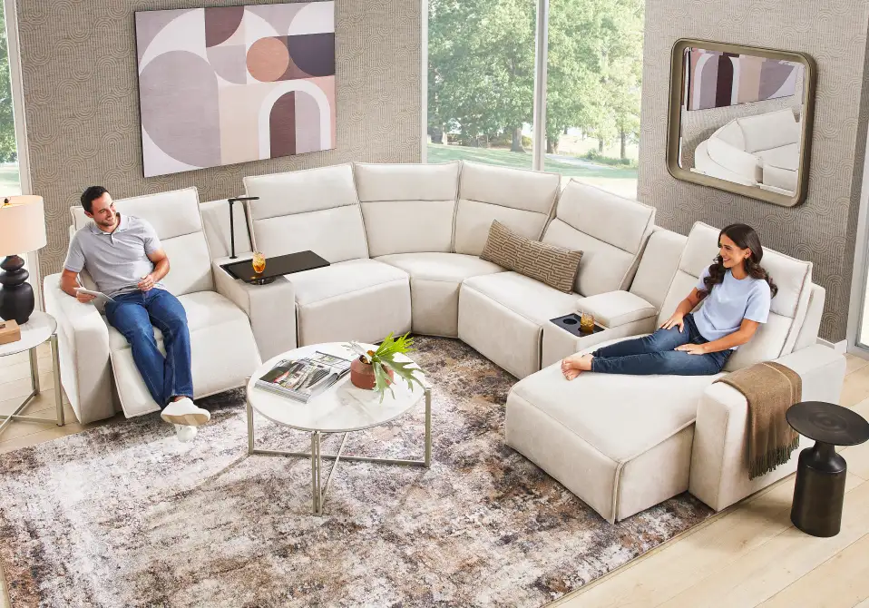 A sectional sofa with two people sitting on it.
