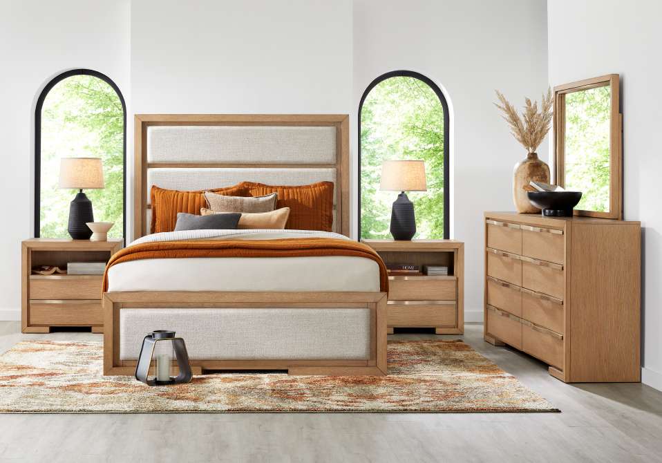 Bedroom furniture set with a bed, nightstands, dresser, and rug.
