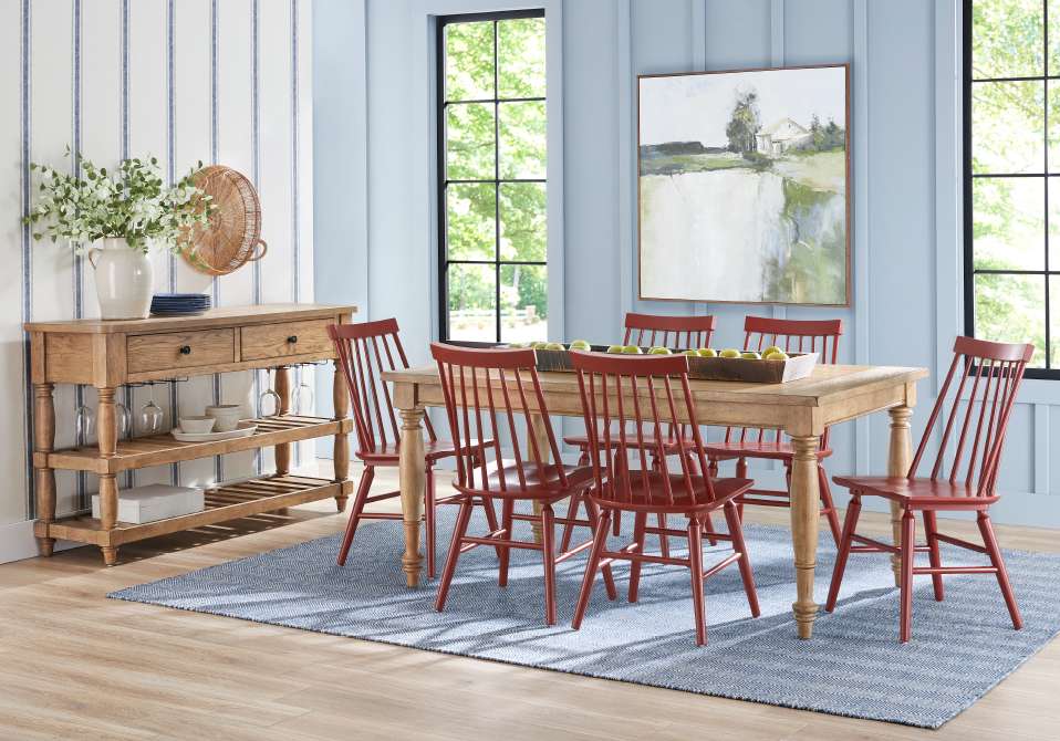 Dining room with a wooden table, red chairs, and a blue rug.
