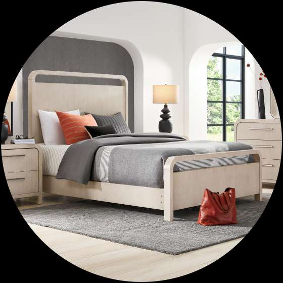 A bedroom with a bed, nightstand, dresser, and a rug.
