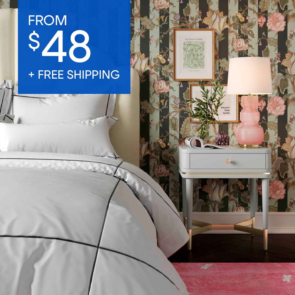 From $48 + Free Shipping. A bed with white bedding and a nightstand with a pink lamp.
