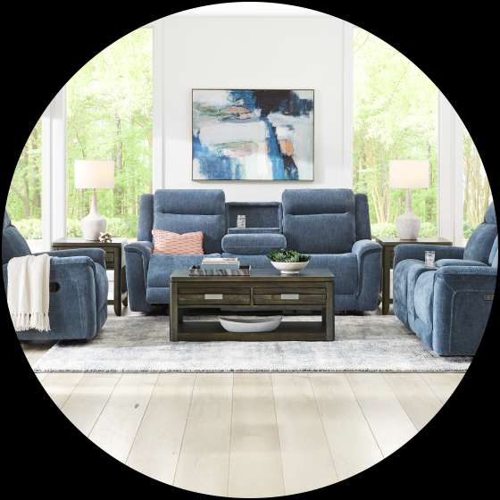 Living room furniture set with blue recliners, a coffee table, and a rug.
