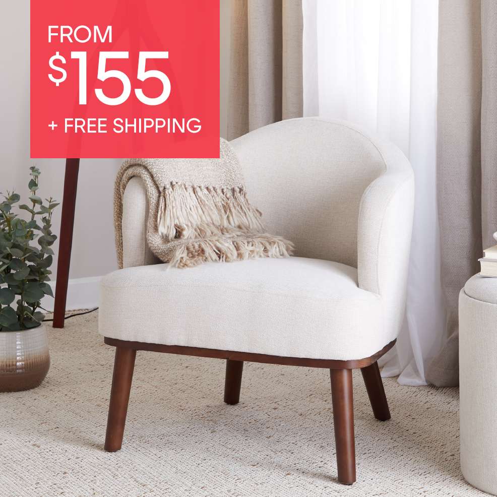 FROM $155 + FREE SHIPPING. A cream-colored armchair with wooden legs and a blanket.
