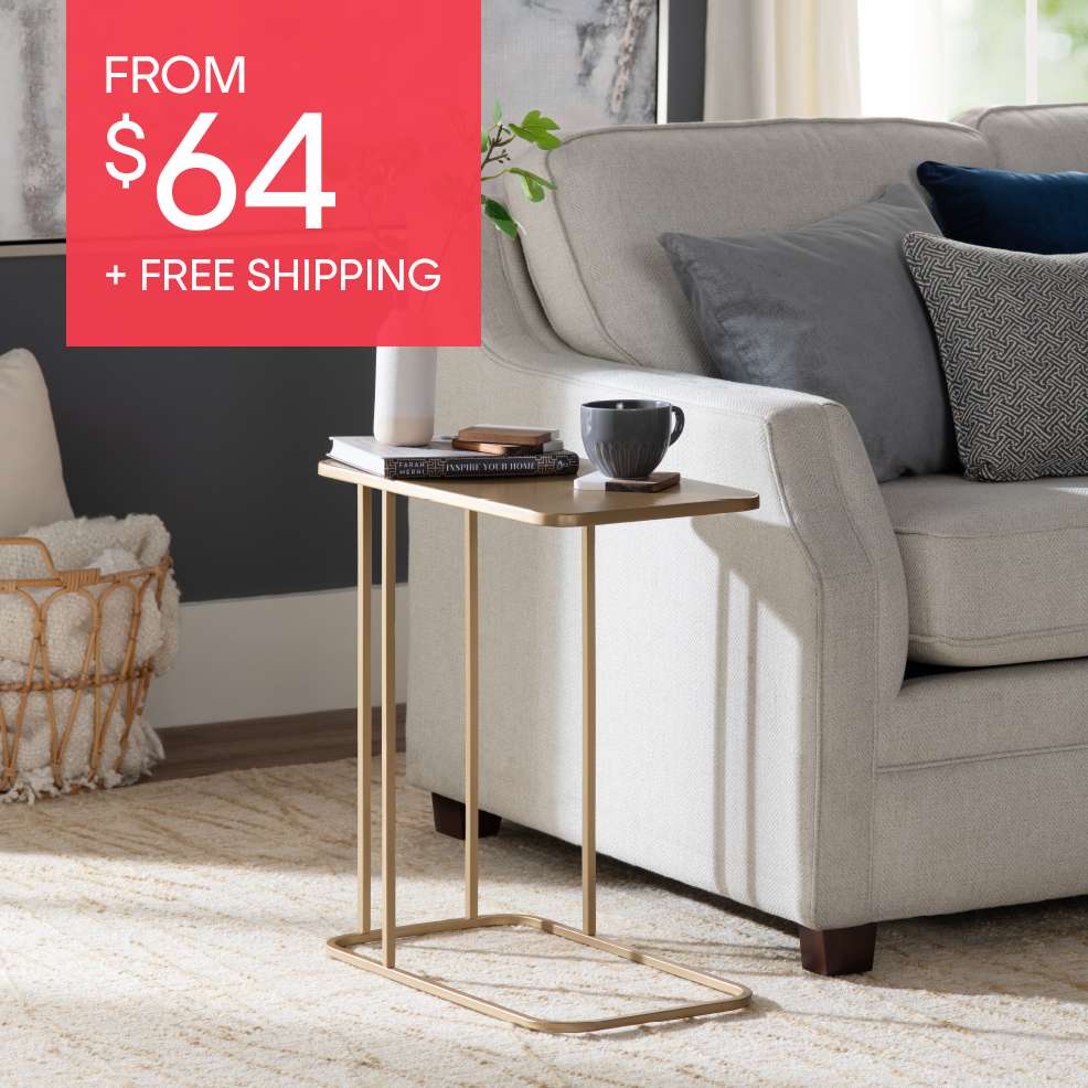 FROM $64 + FREE SHIPPING. A gold side table next to a couch.
