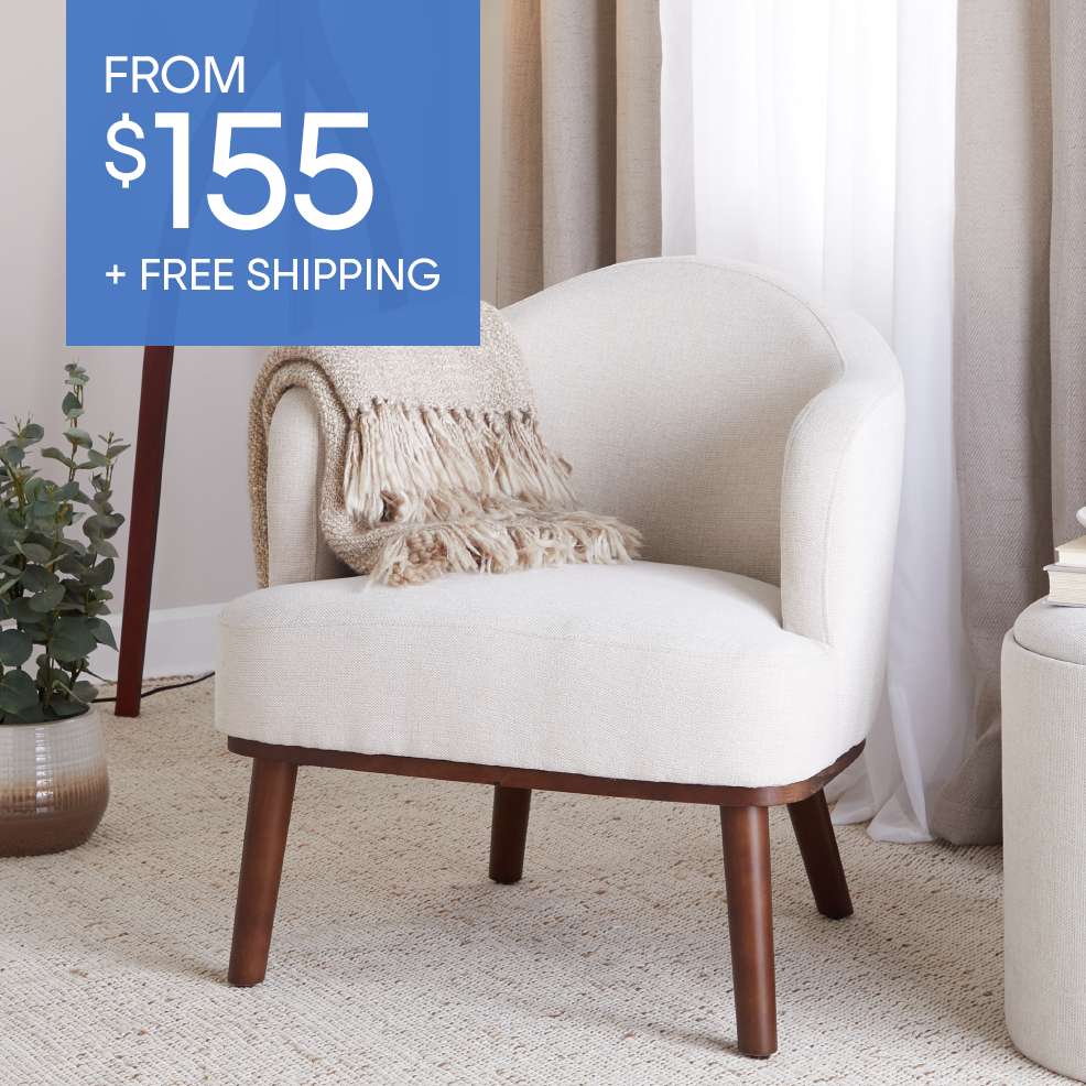 FROM $155 + FREE SHIPPING. A cream-colored armchair with a blanket on the seat.
