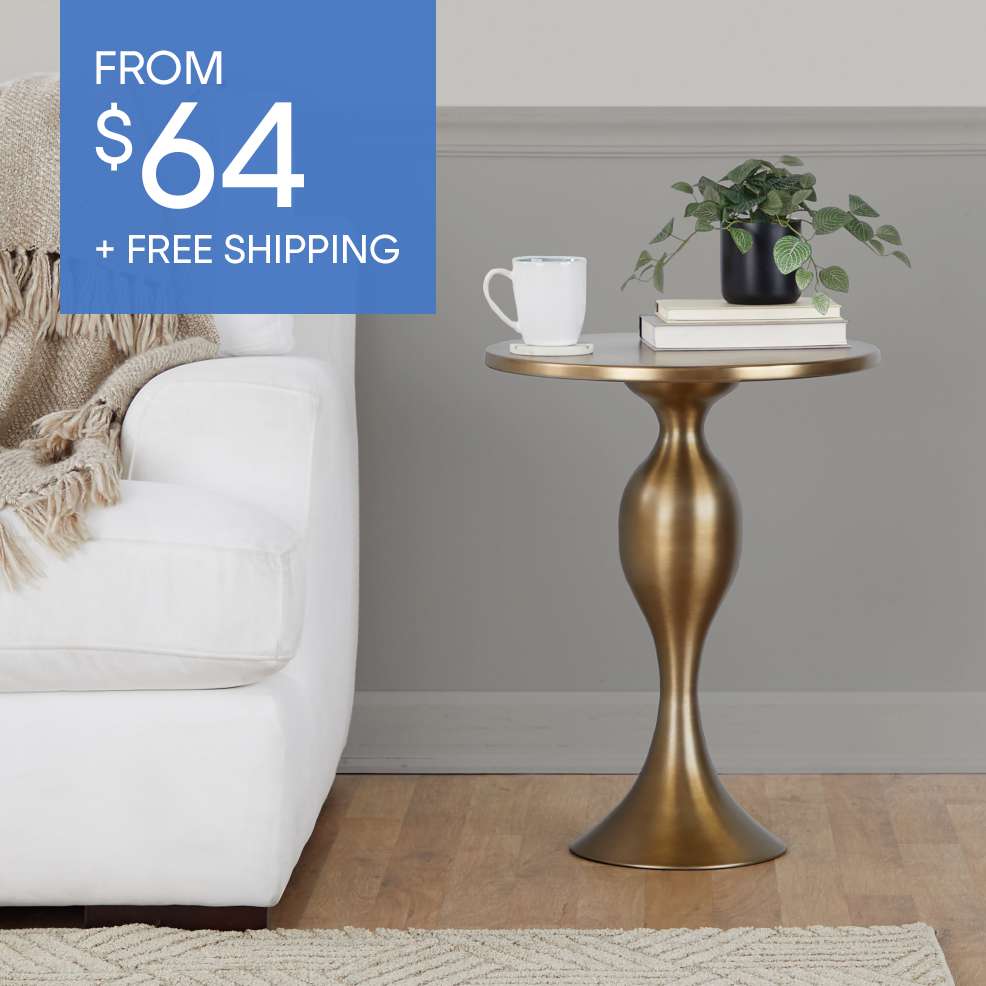 FROM $64 + FREE SHIPPING. A gold side table with a plant, books, and a mug.
