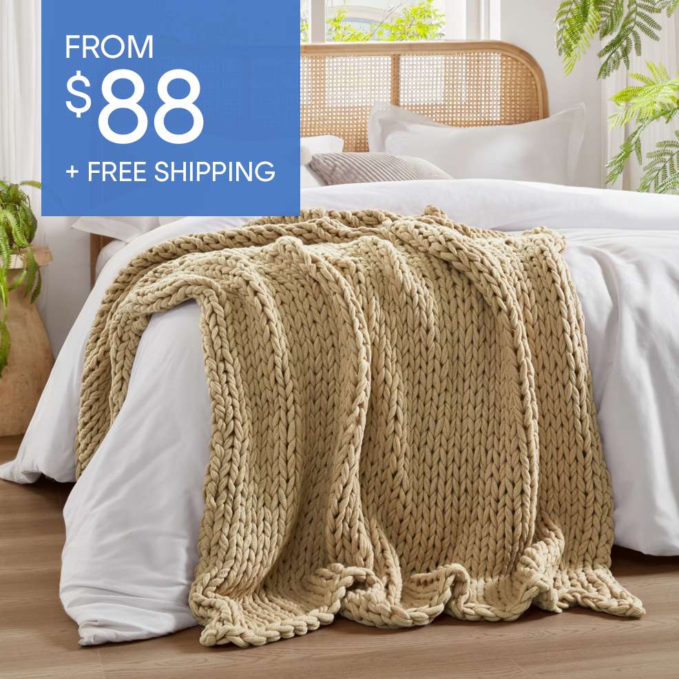 FROM $88 + FREE SHIPPING. A beige chunky knit blanket on a bed.
