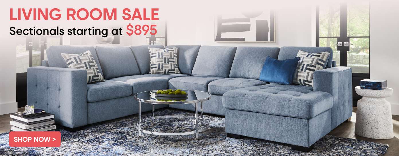 LIVING ROOM SALE. Sectionals starting at $895. A blue sectional sofa with pillows.
