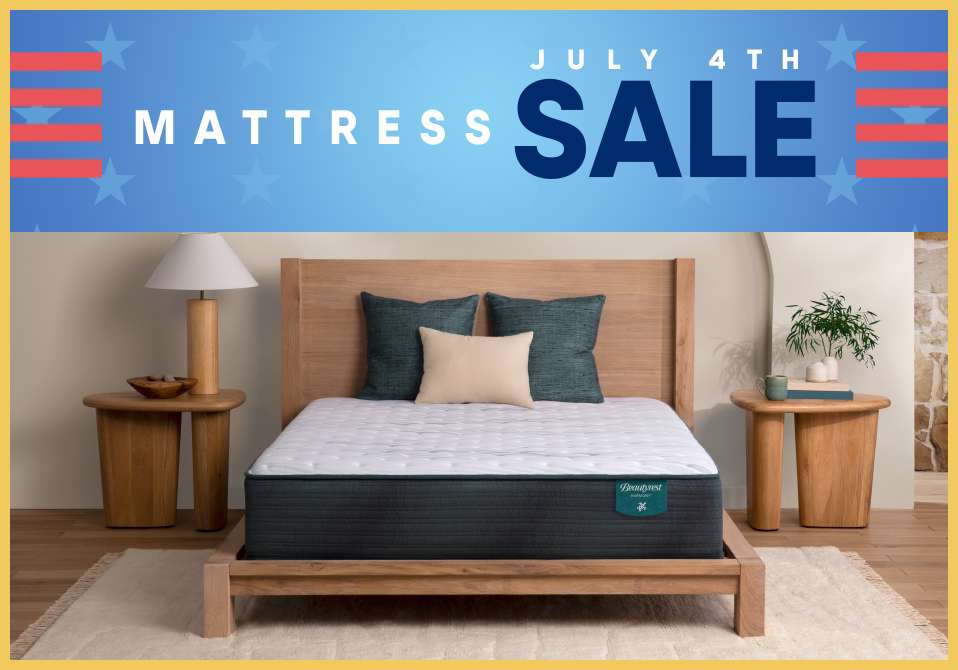 Mattress sale. A mattress on a wooden bed frame with pillows.
