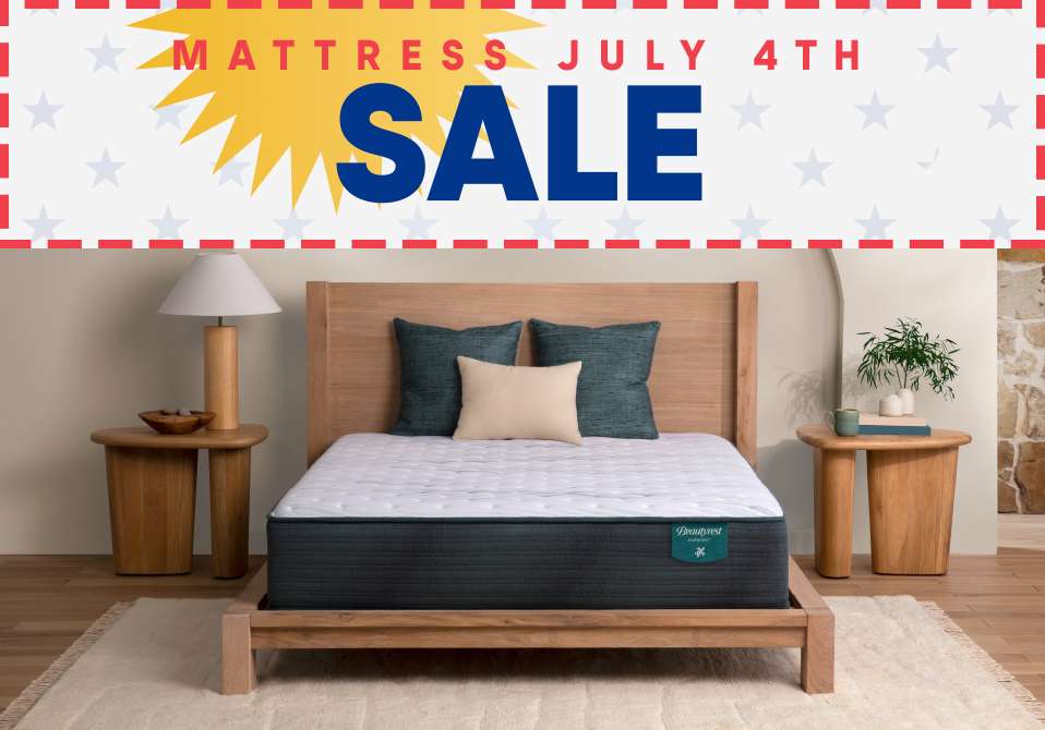 MATTRESS JULY 4TH SALE. A bed with pillows and a mattress.
