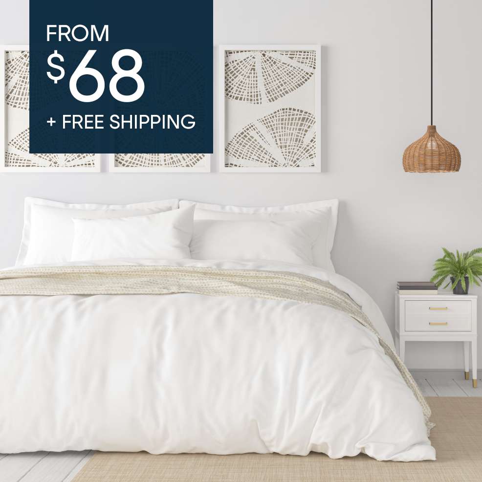 FROM $68 + FREE SHIPPING. A white bed with white bedding, a beige throw, and a white nightstand.
