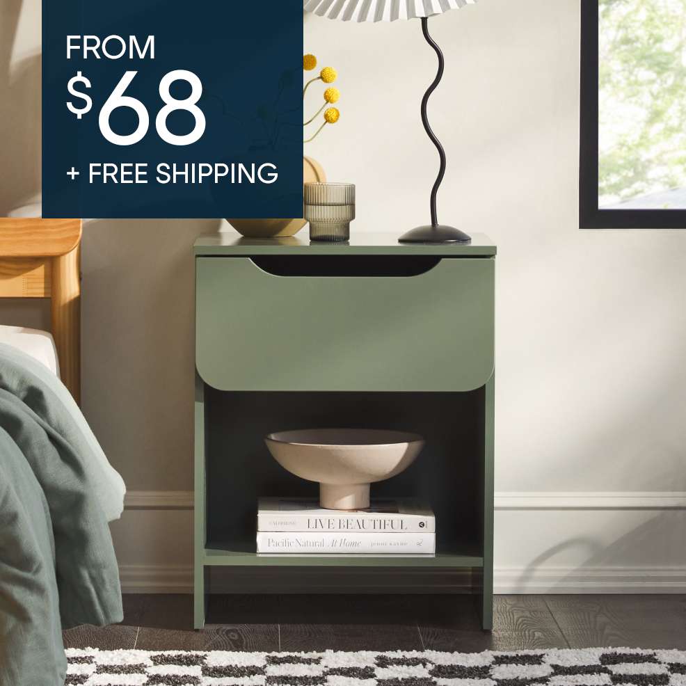 Green nightstand with a drawer and open shelf, with books and a bowl.
