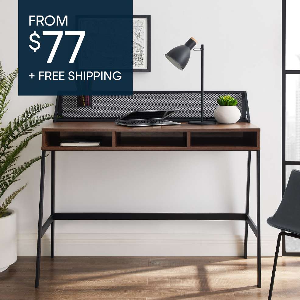 FROM $77 + FREE SHIPPING. A brown desk with black legs, a laptop, and a lamp.
