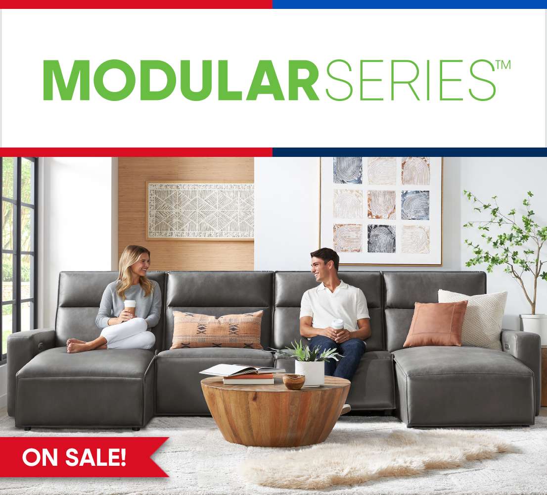 MODULAR SERIES™ ON SALE! A gray modular sofa with two people sitting on it.
