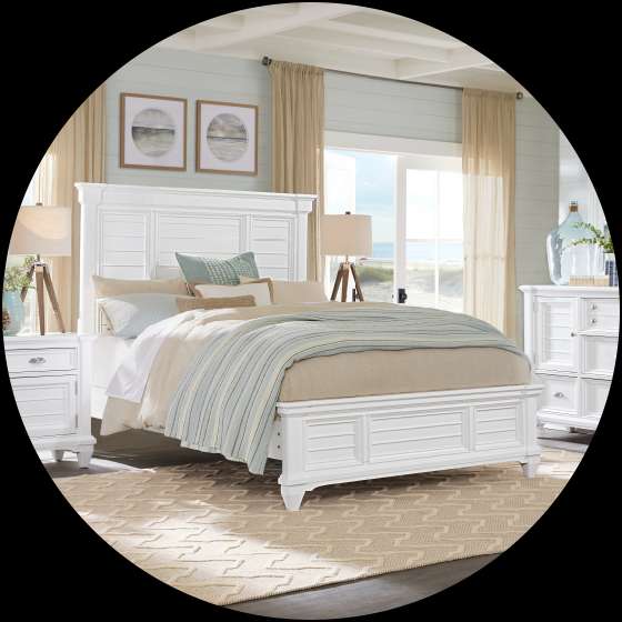 White bedroom set with a bed, nightstand, and dresser.

