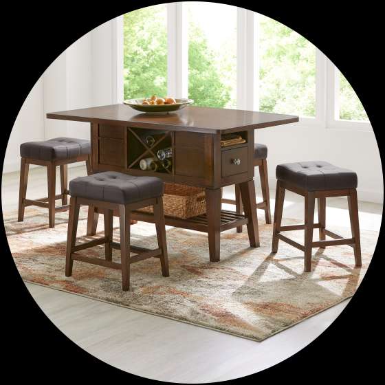 A dark brown kitchen island with four matching stools on a patterned rug.
