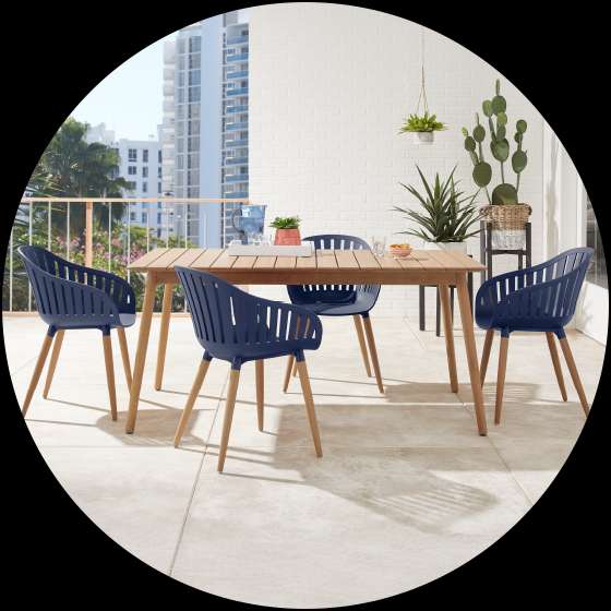 Outdoor dining set with a wooden table and navy blue chairs.
