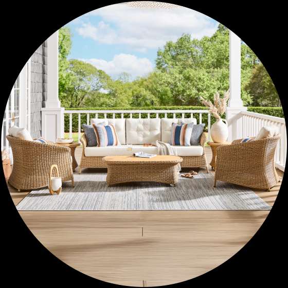 Outdoor wicker furniture set on a porch.
