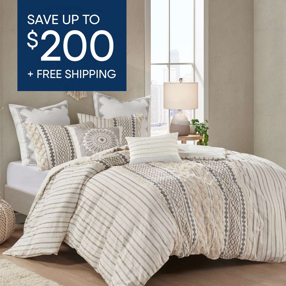 SAVE UP TO $200 + FREE SHIPPING. A bed with a patterned comforter and pillows.
