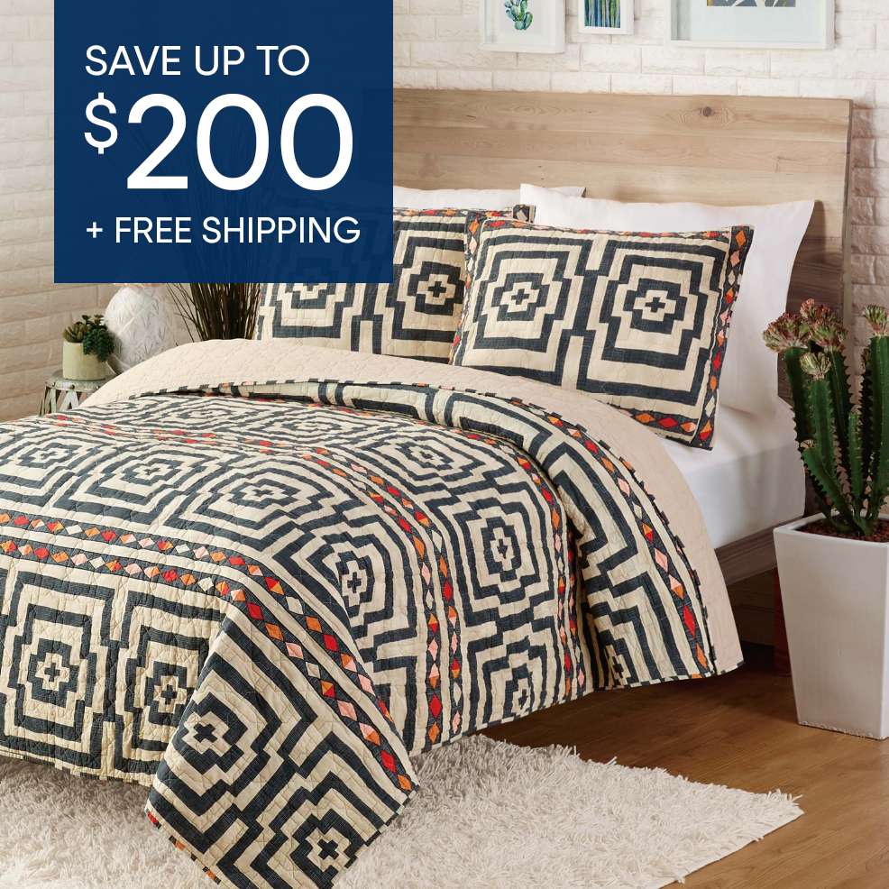 SAVE UP TO $200 + FREE SHIPPING. A bed with a geometric patterned quilt and pillows.
