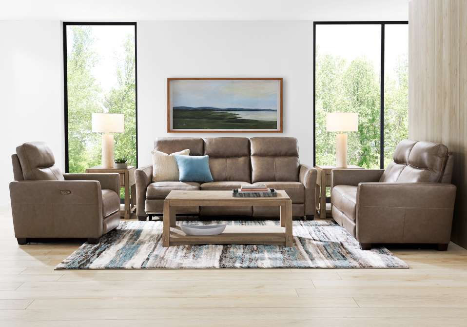Living room with brown leather sofa, two armchairs, and a rug.
