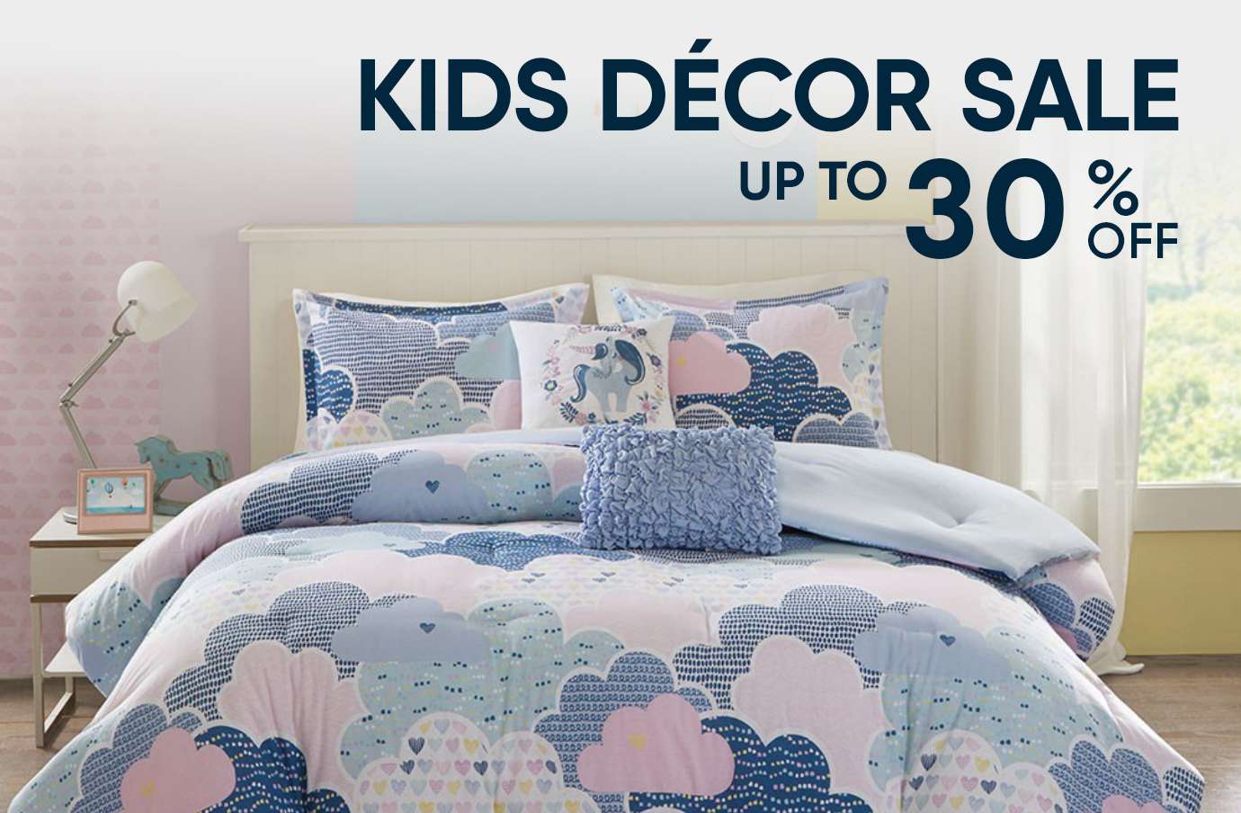 KIDS DÉCOR SALE UP TO 30% OFF. A bed with a cloud-patterned comforter and pillows.
