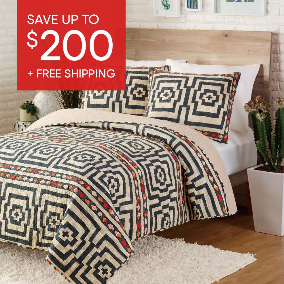 SAVE UP TO $200 + FREE SHIPPING. A bed with a geometric patterned quilt and pillows.