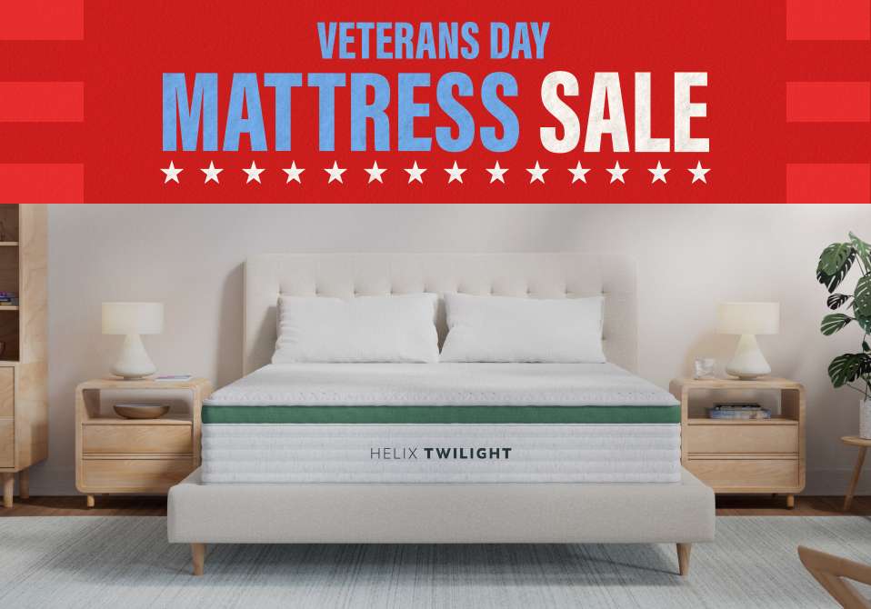 Veterans Day Mattress Sale. A bed with two pillows and two nightstands.
