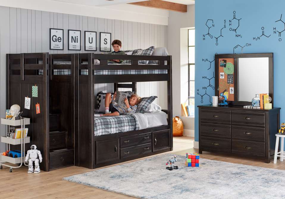 A bunk bed with two boys reading, a dresser, and a rug.
