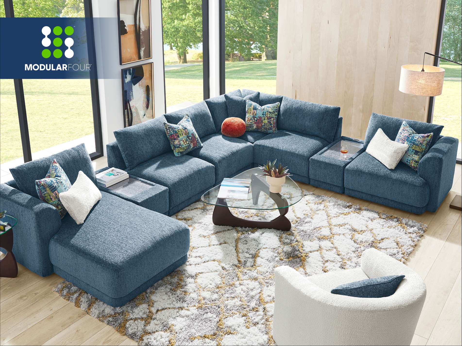 MODULARFOUR. Blue modular sectional sofa with patterned pillows.
