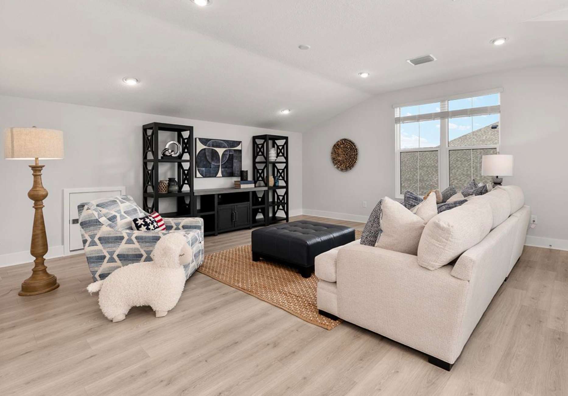 Living room with a sofa, armchair, and black furniture.
