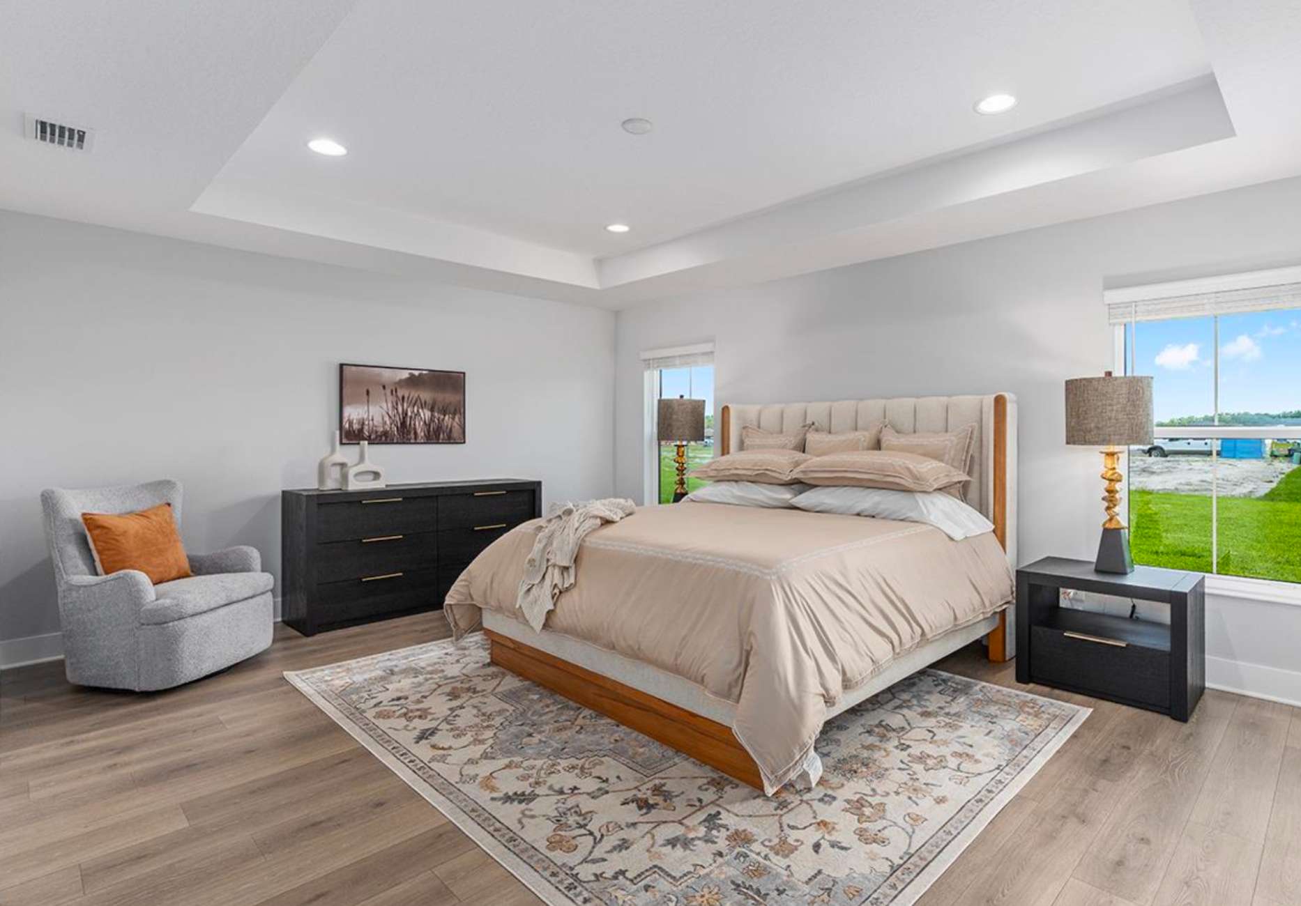 A bedroom with a bed, a chair, a dresser, and a rug.
