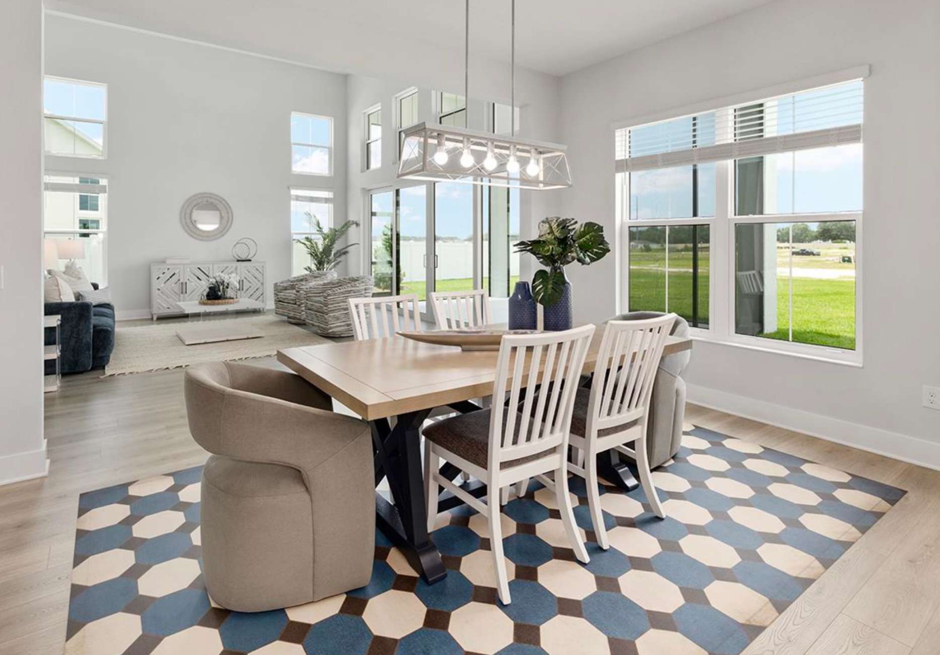Dining room with a table, chairs, and a patterned rug.
