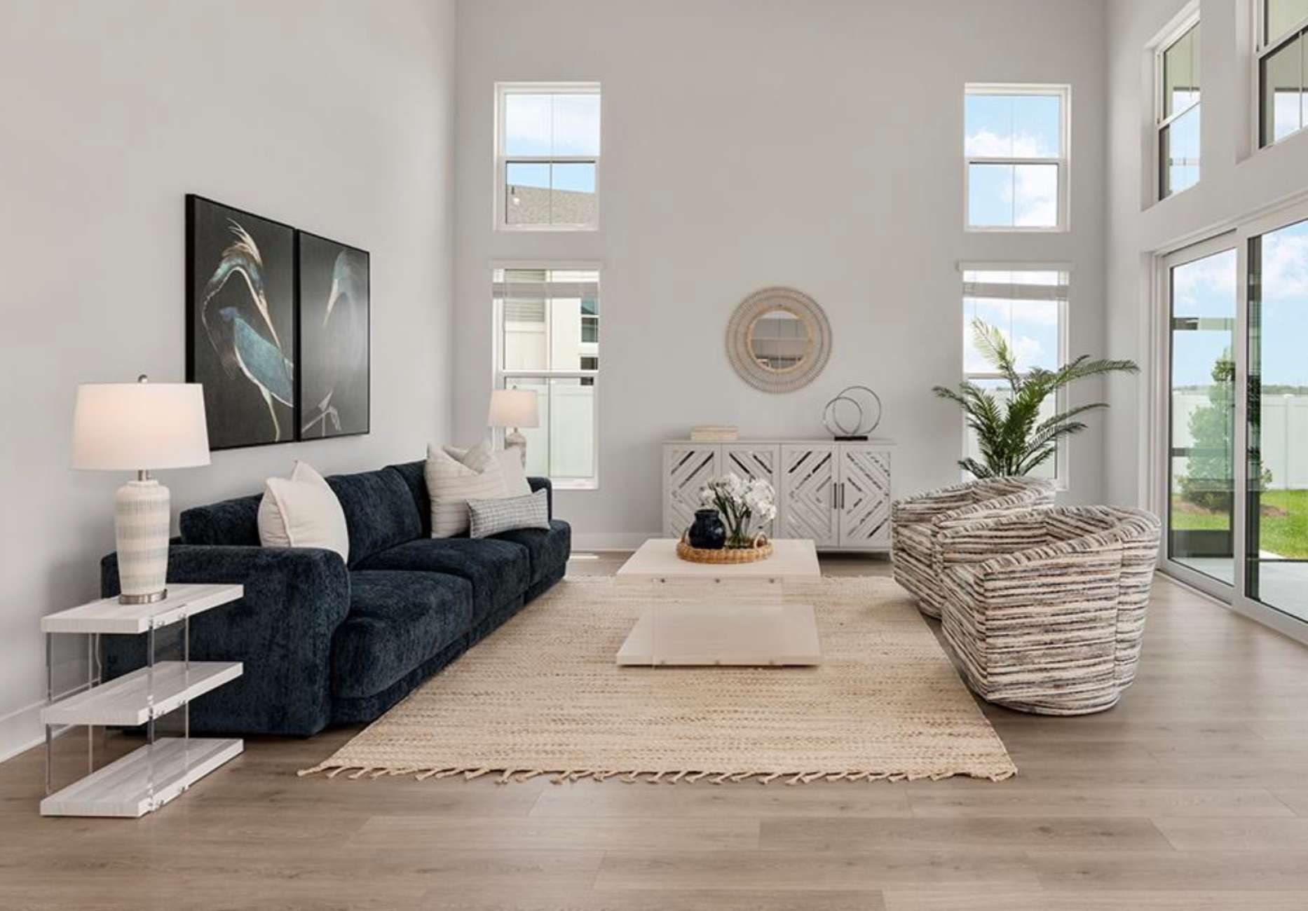 Living room with a navy blue sofa, two armchairs, and a rug.
