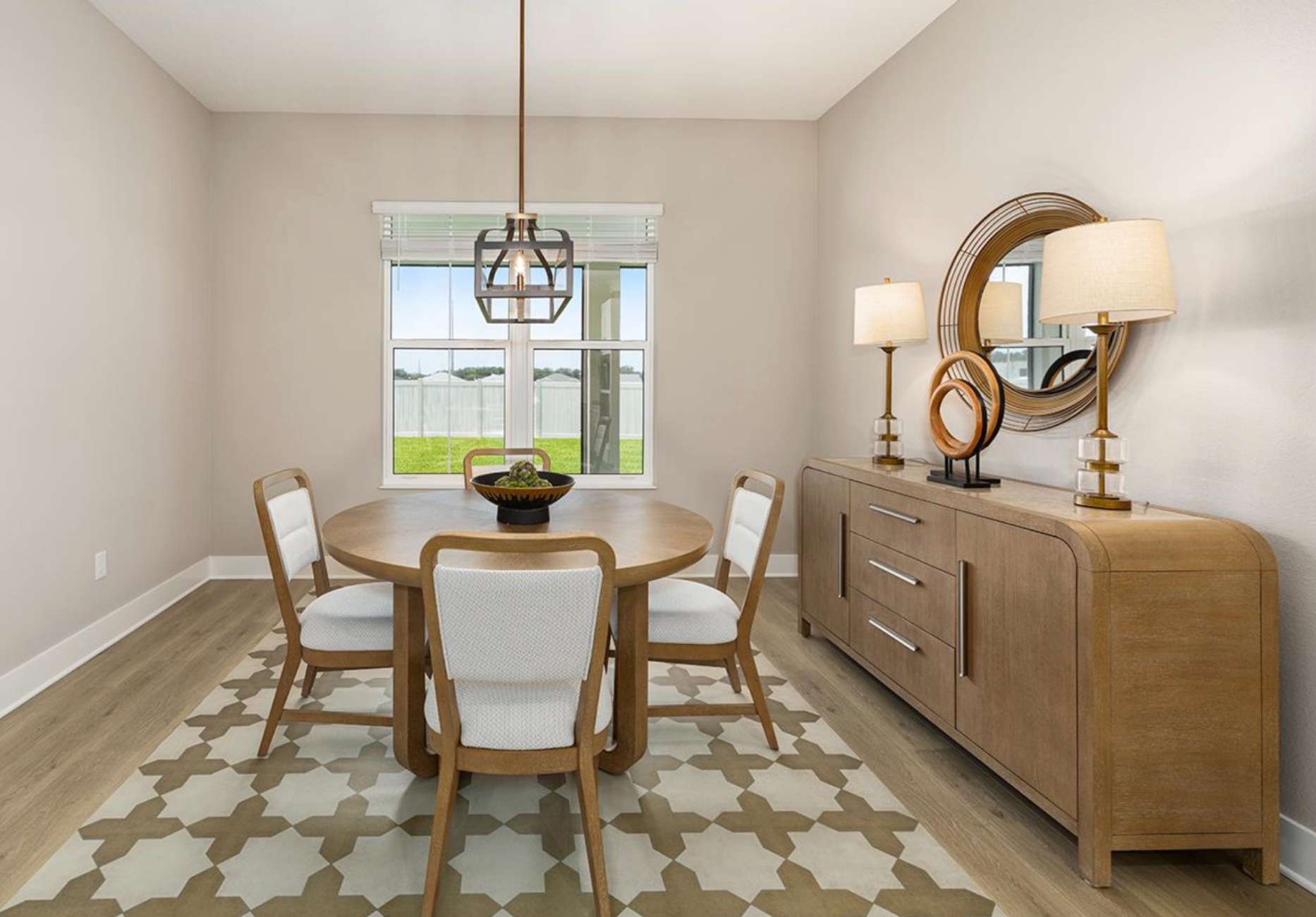 Dining room with a round wooden table, chairs, and a buffet.
