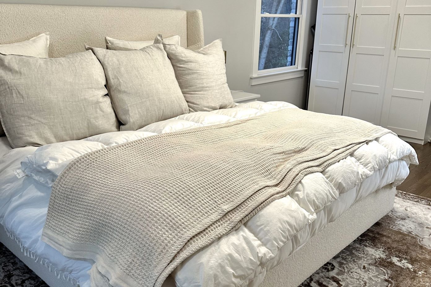 tan bedframe with white bedding