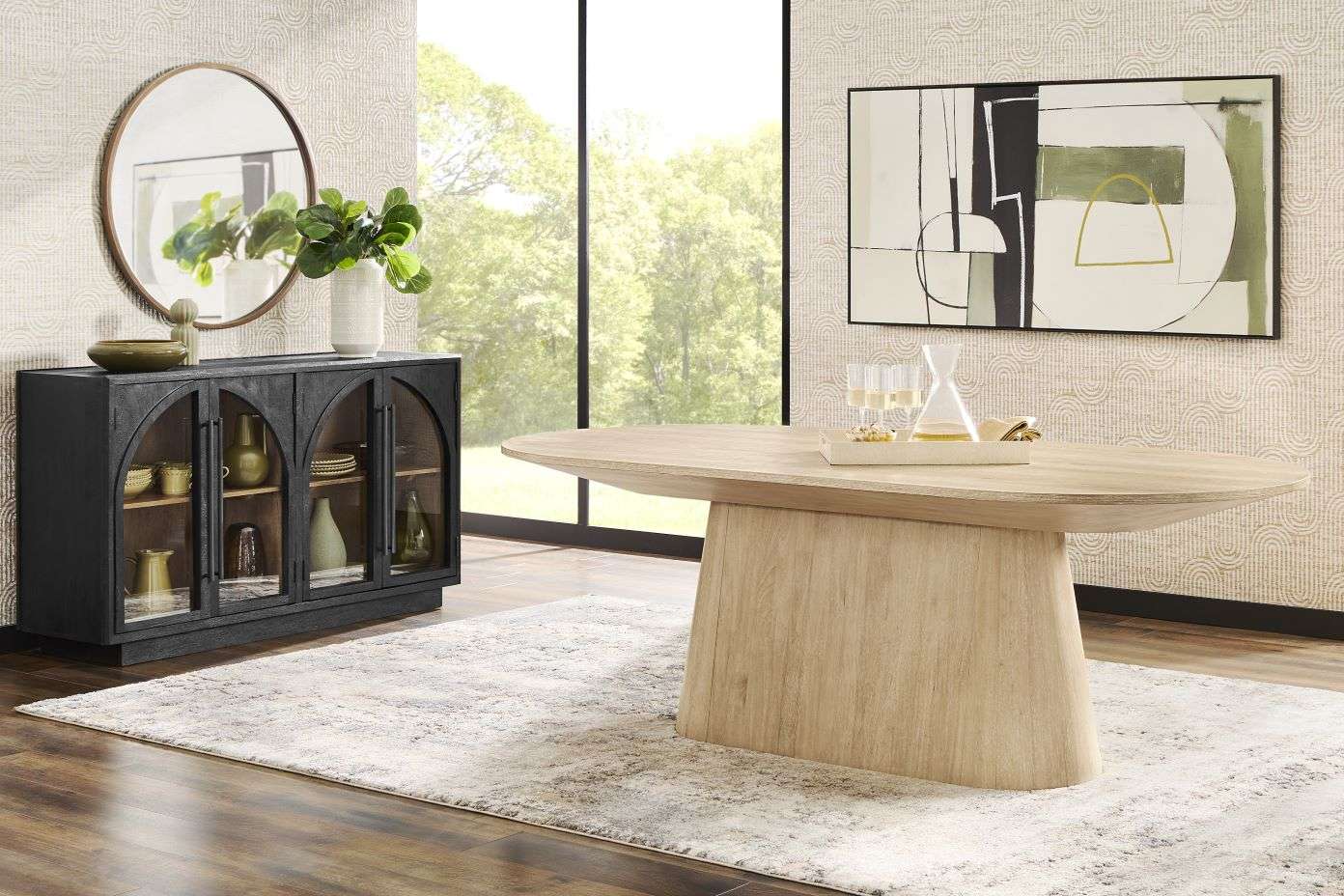 A dining room with a wooden table, black cabinet, and abstract art.