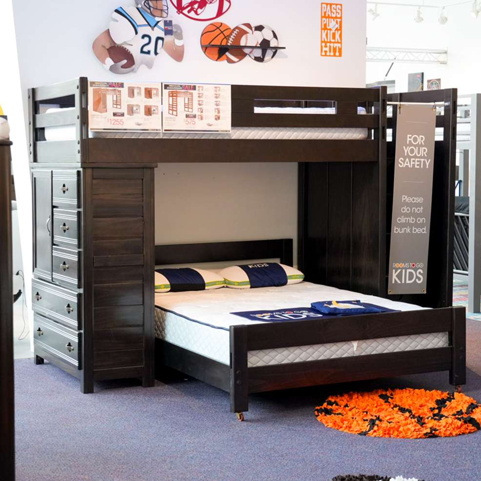 A dark brown bunk bed with a dresser and a sign that says "FOR YOUR SAFETY".
