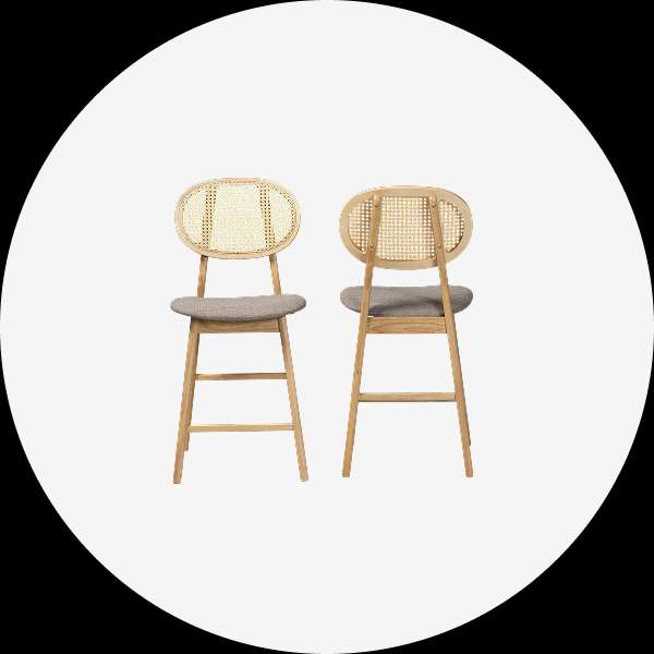 Two wooden bar stools with woven backs and gray seats.
