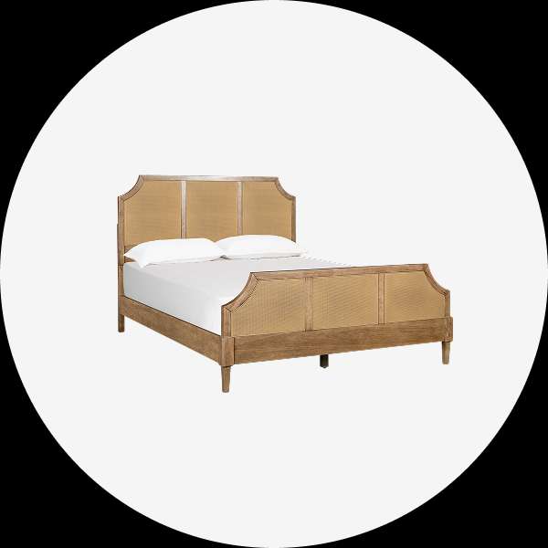 Wooden bed with a woven headboard and footboard.
