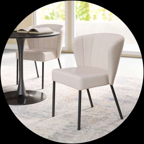Beige upholstered dining chair with black legs.
