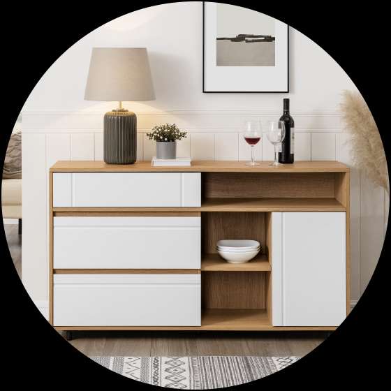 A wooden sideboard with white drawers and a cabinet, topped with a lamp, wine, and decor.
